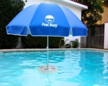 A blue umbrella sitting in the middle of a pool.