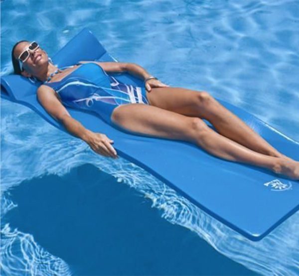 A woman laying on the water in her swim suit.