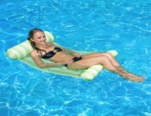 A woman in black bikini laying on an inflatable raft.